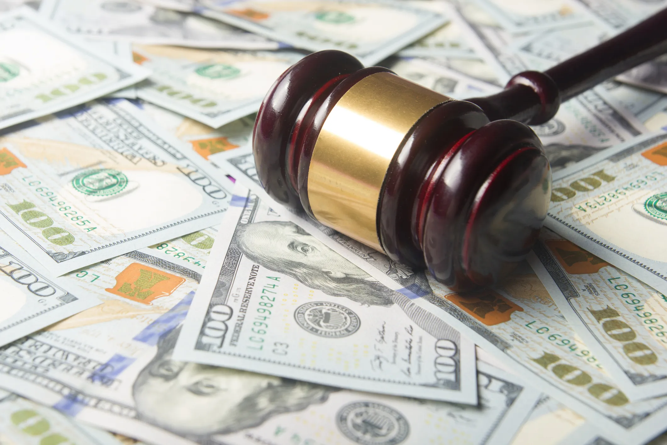 A gavel on a pile of $100 bills.