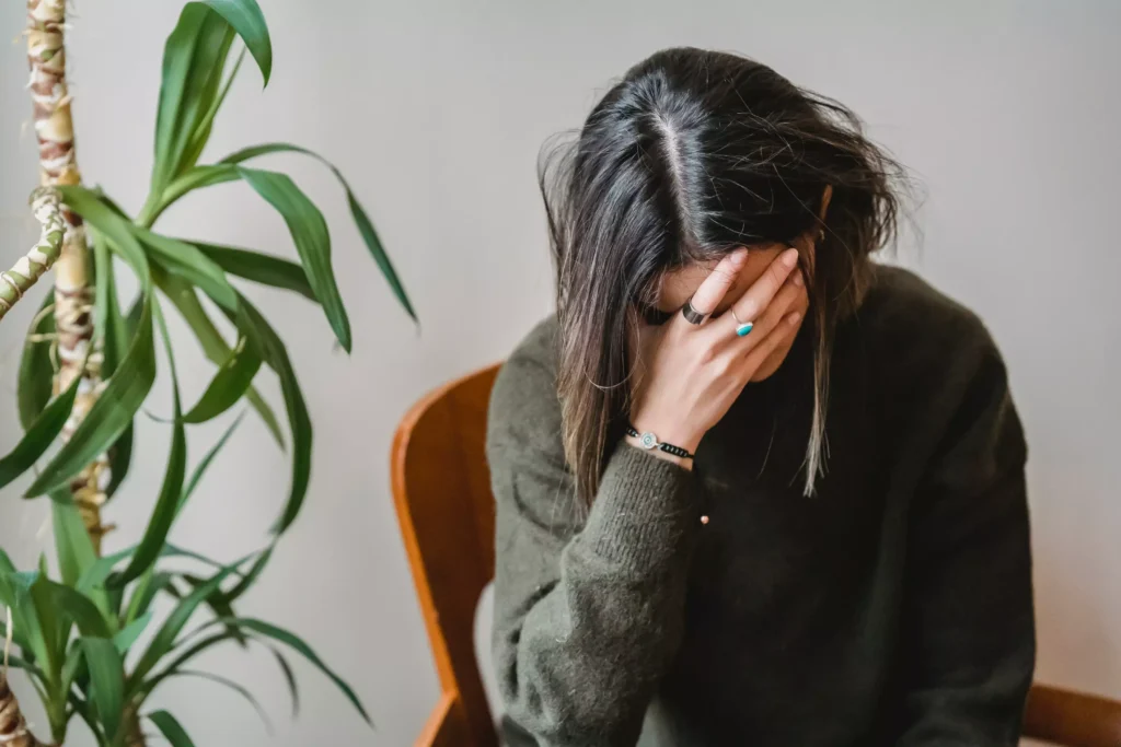 A woman upset with her head in her hands.